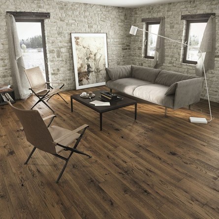 A living room with a sofa, table and chairs on wooden flooring.