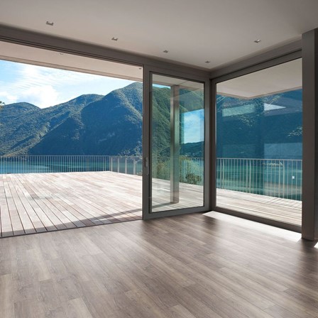 A room with glass doors and a wooden deck.