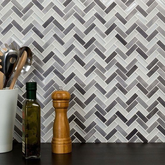 A kitchen with a grey herringbone tile design