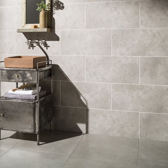 A wet room with pale grey stone effect ceramic tiles