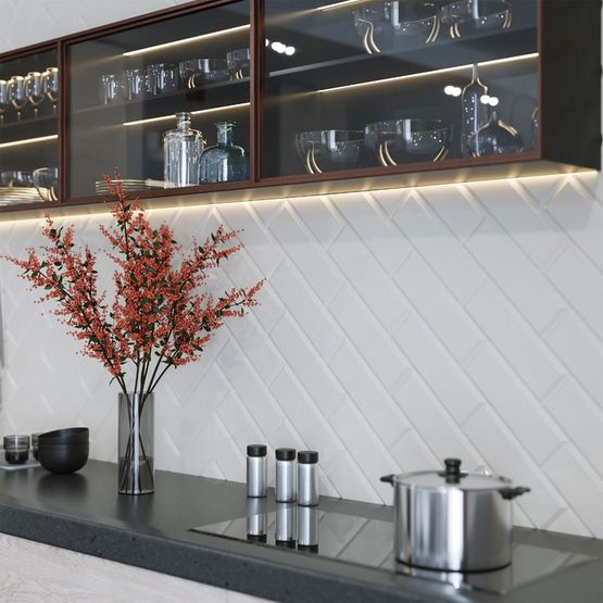 A kitchen counter with a white bevelled ceramic wall tile for splashback