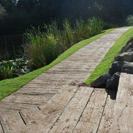 A wooden walkway next to a pond.