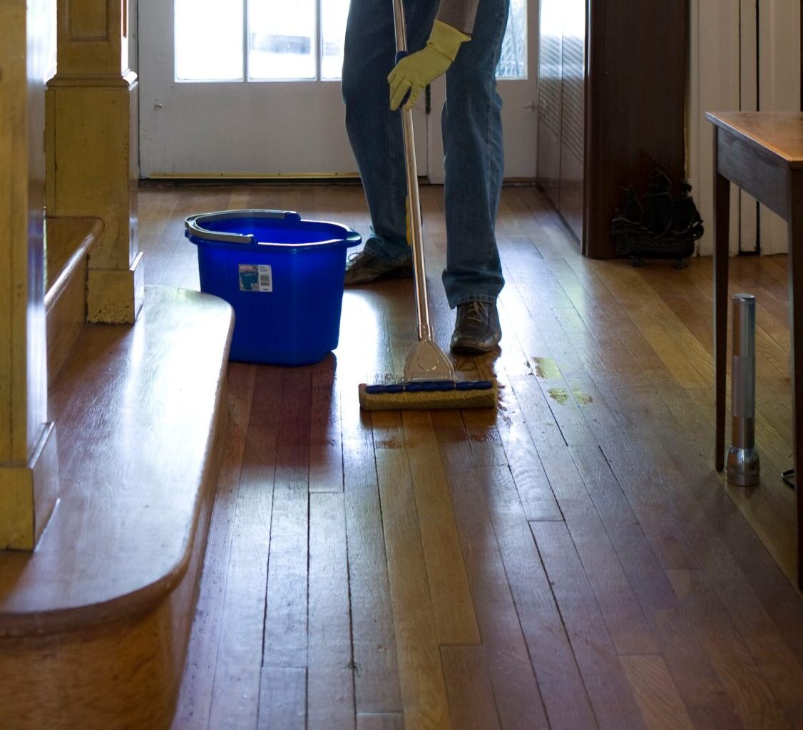 Man sweeping wooden flooring