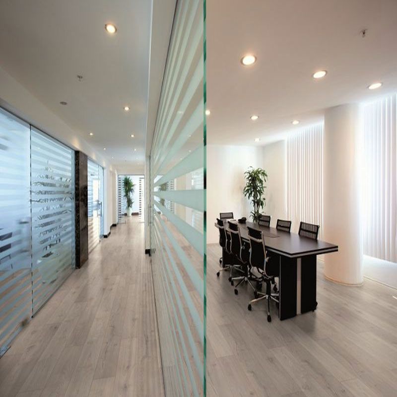 A conference room with a table, chairs and laminate wood effect flooring.