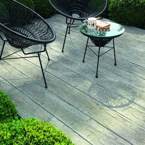 Outdoor composite decking with black chairs and a glass table