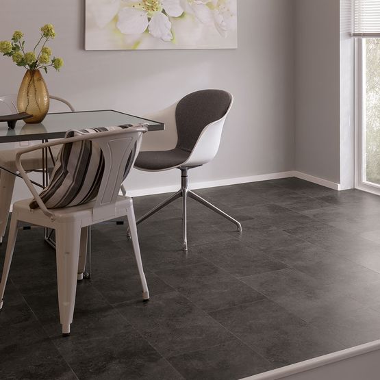 Dining area with grey walls, a table and chairs, and dark grey LVT