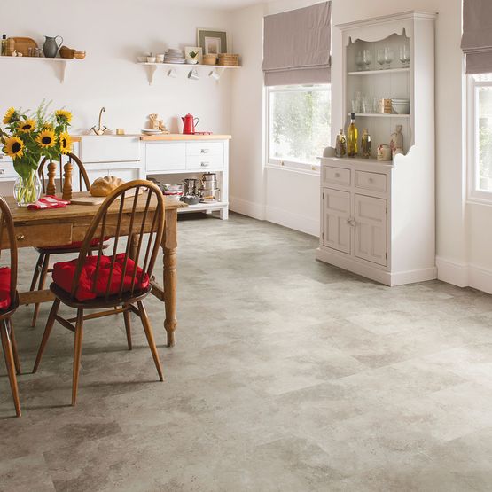 A kitchen with white walls, white cabinets, a wooden table and Palio Core Pienza LVT