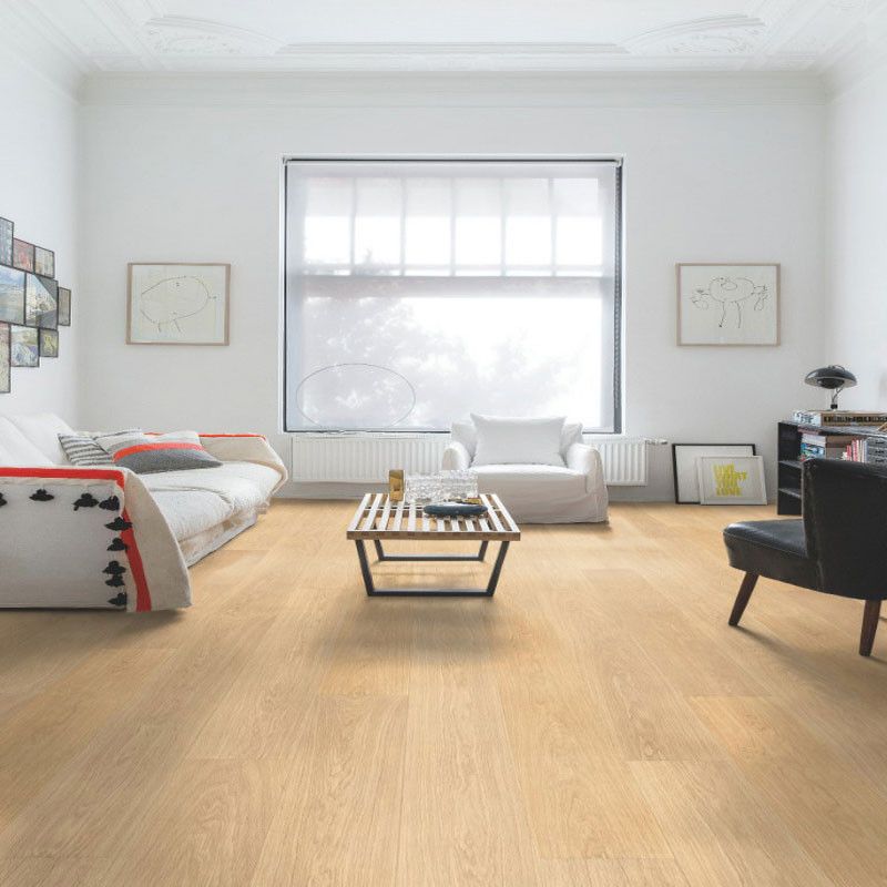 A room with a sofa, coffee table and wood-effect laminate flooring. 