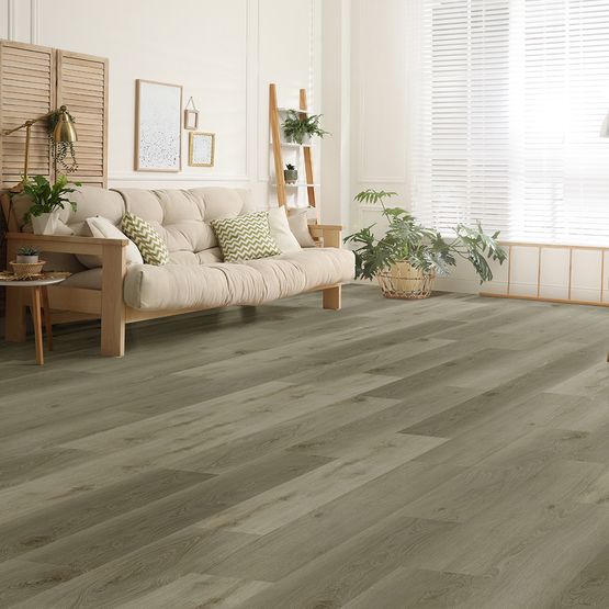 A living room with cream walls, a cream sofa, wooden furnishings and light grey LVT flooring