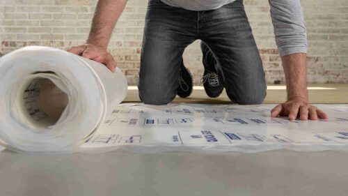 A person rolling out underlay.
