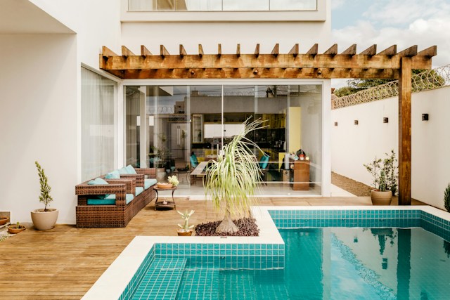 Pergola connected to a house with a swimming pool