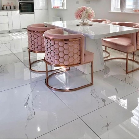 White marble kitchen floor tiles with modern pink and copper chairs.