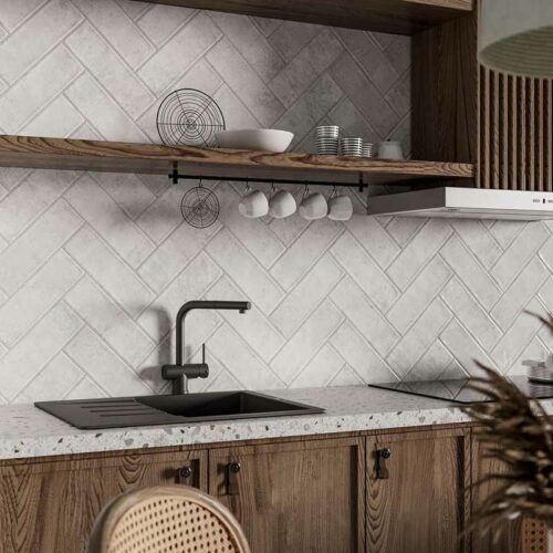 White wall tiles with a pressed edge in a kitchen with a sink and shelves.